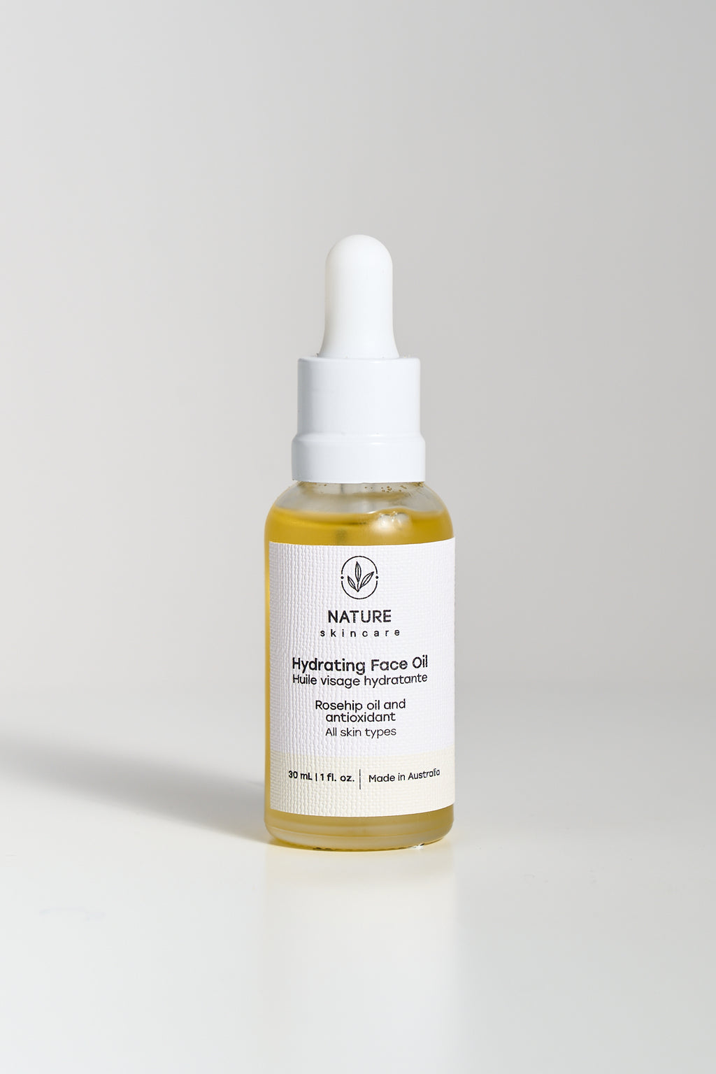 Glass dropper bottle of hydrating face oil on a clean neutral background