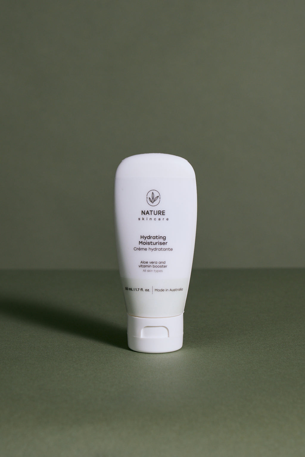 Australian organic hydrating moisturiser for soft balanced skin standing in green background