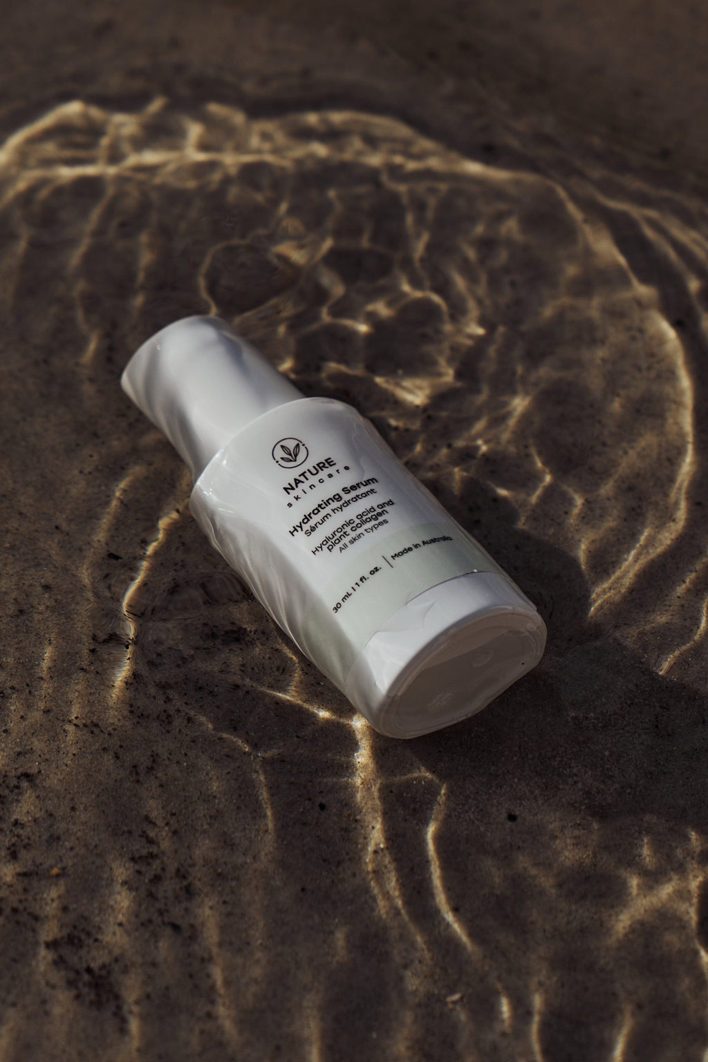 Hydrating Face serum bottle in water with visible logo