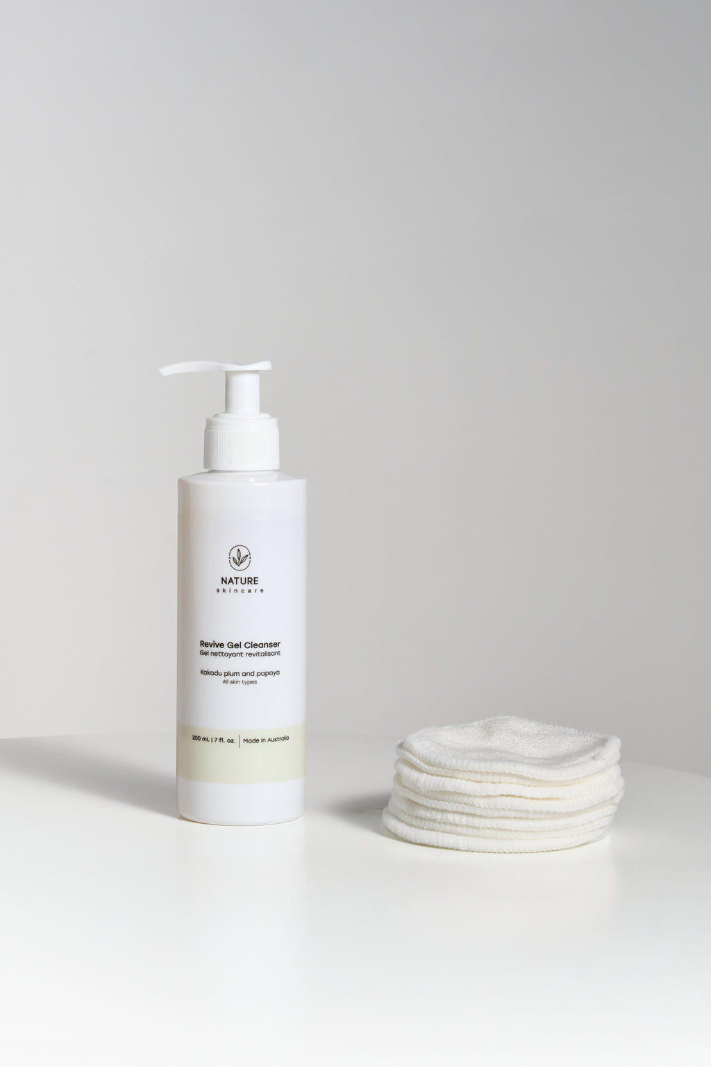Organic reusable cotton pads with revive gel cleanser next to each other